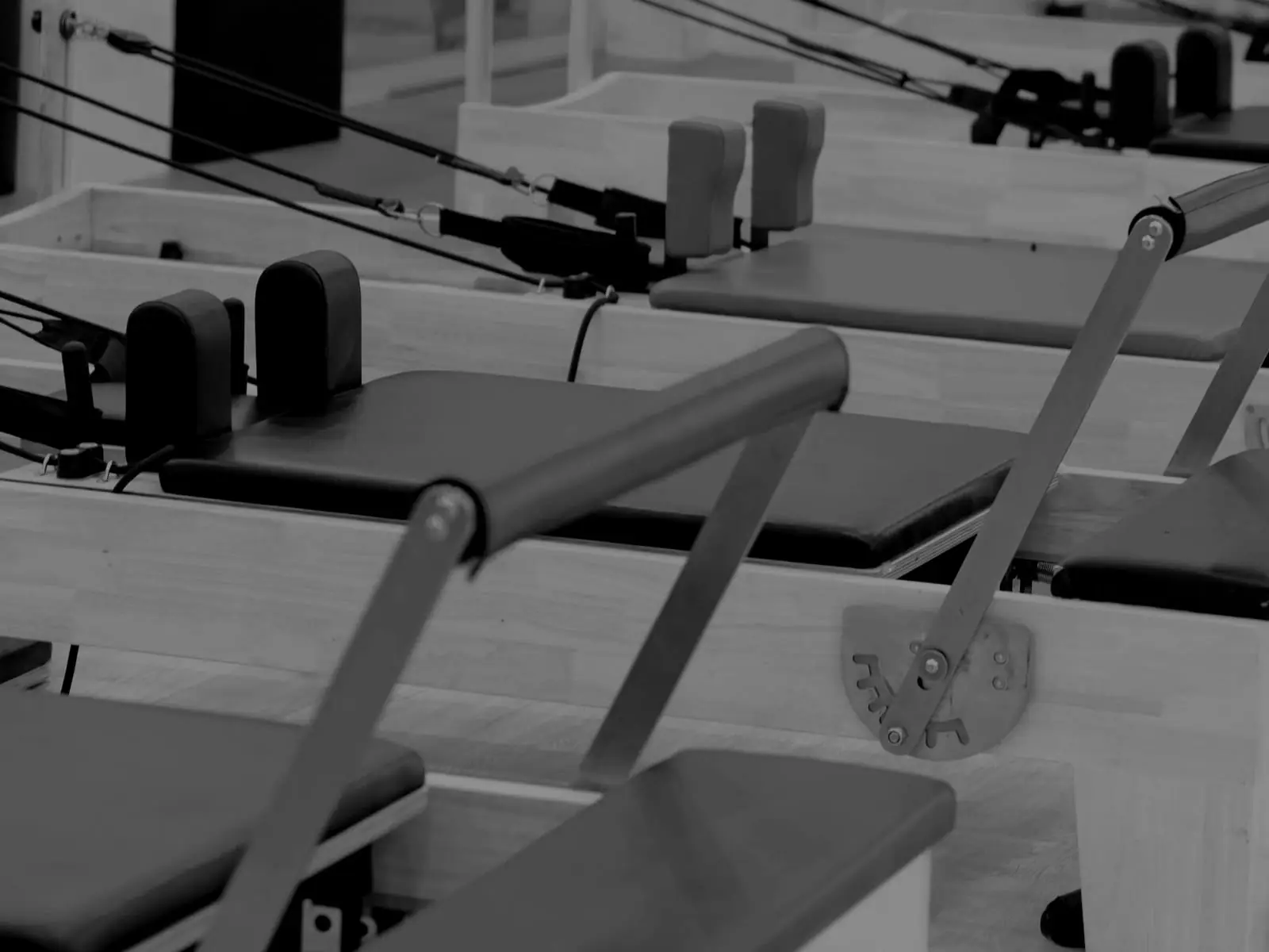 One reformer carriage close up, its footbar and shoulder blocks in low light.