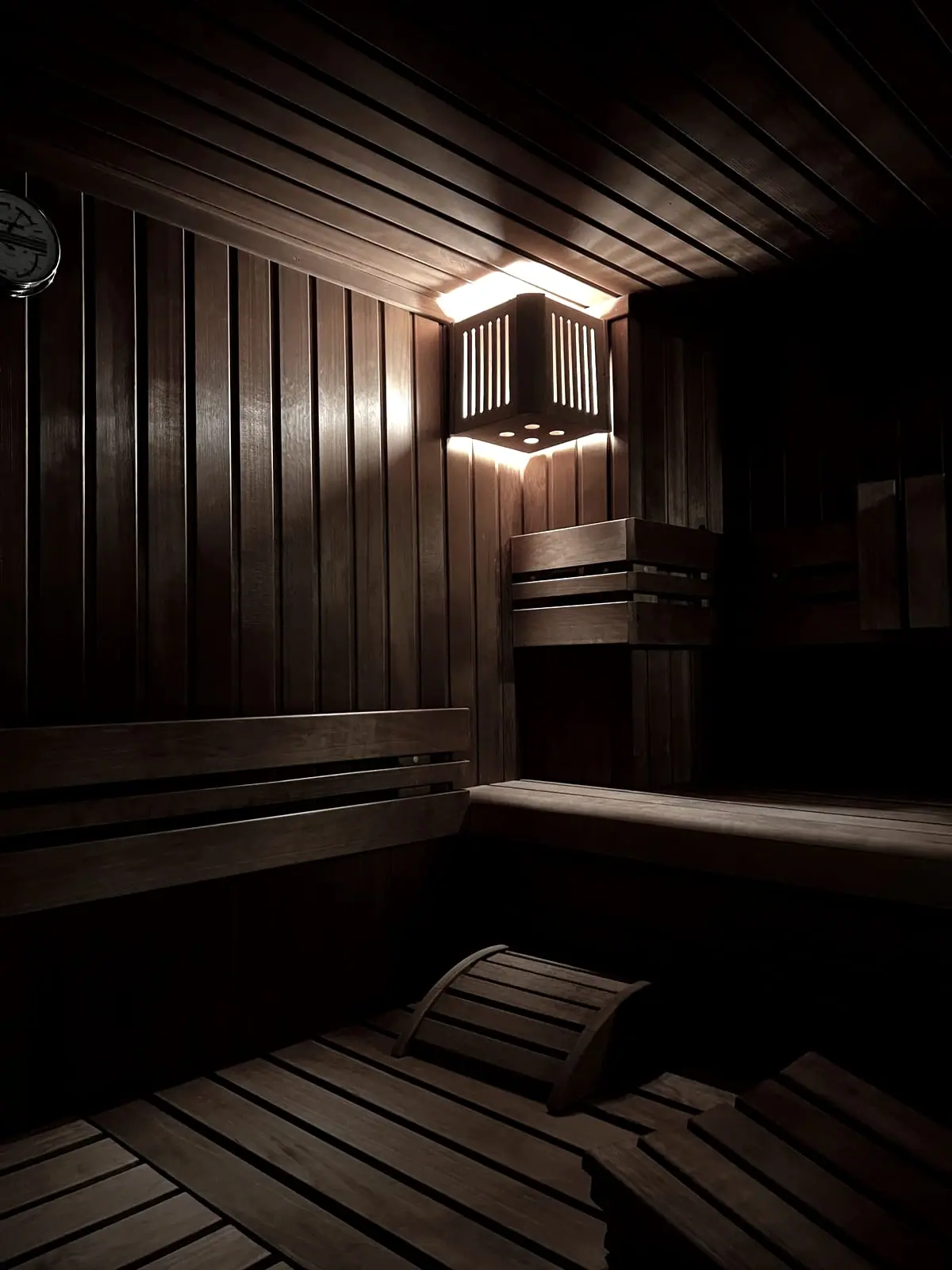 The recovery suite, a warm-lit sauna bench in near dark.